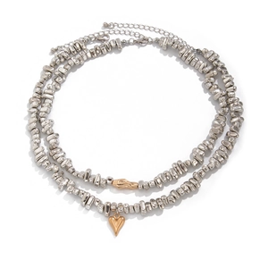 Double layered necklace with irregular silver beads and heart pendant on white background