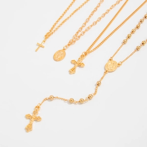Vue détaillée de quatre colliers religieux dorés avec pendentifs croix et médaillon
