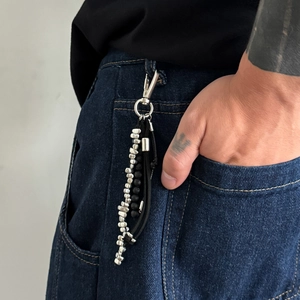 Détail d'une chaîne de taille hip-hop multicouche avec perles argent et cordons noirs