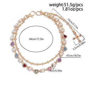 Detail view of multi-layer gold waist chain with pearls and colorful crystal cross