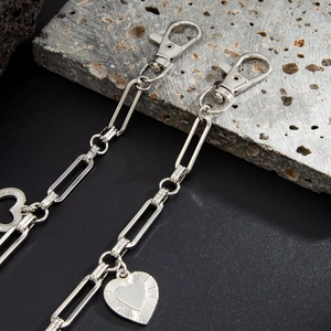 Détail de la chaîne de pantalon avec pendentif cœur argenté et fermoir mousqueton poli