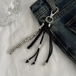 Porte-clés de style punk avec perles CCB et gland noir sur un jean bleu classique