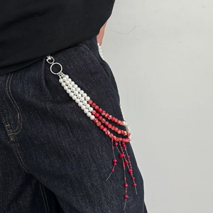 Multi-layer pearl waist chain with red crystal pendants and marble beads on denim