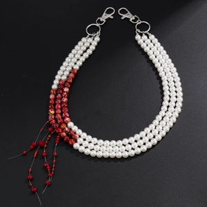 Detailed view of triple-layered trouser chain with faux pearls and marble beads