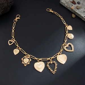 Collana dorata con ciondoli a cuore e doppi moschettoni su uno sfondo nero opaco