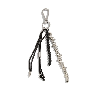 Porte-clés style industriel avec pierres de lave noires et perles métalliques sur fond blanc
