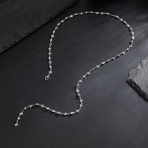 Detail of silver heart-shaped metal plates and sparkling crystals on long chain necklace