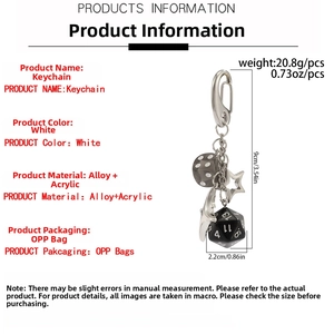 Close-up of star, moon and dice charms on a silver alloy keychain with lobster clasp