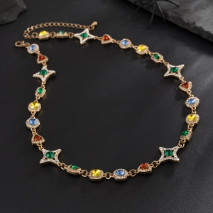 Detalle del collar dorado con piedras preciosas geométricas y cristales de colores