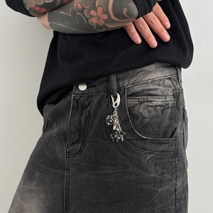 Men's star dice keychain accessory with silver hook and black resin charms on jeans