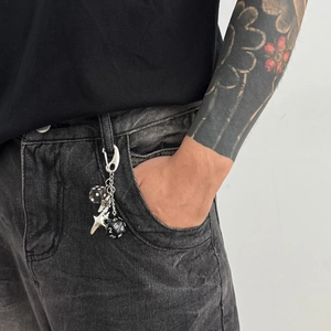 Hip-hop silver metal keychain featuring star and dice charms on black denim jeans