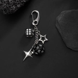 Macro detail of gothic keychain with pentagram star, dice charms and metal carabiner