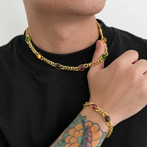 Men's gold Cuban link necklace and bracelet set with multi-color gemstones on model