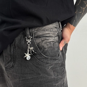 Close-up of a street style keychain with a black billiards 8-ball and star pendant