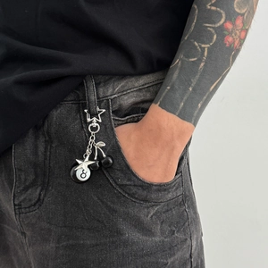 Streetwear keychain with black 8-ball and cherry charms on grey denim jeans