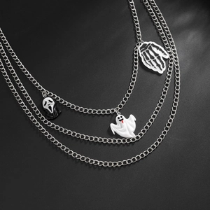 Close-up of gothic layered silver chains with ghost, skull hand, and scream mask pendants