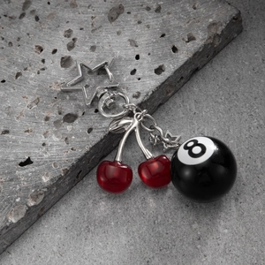 Detailed view of silver star buckle with red resin cherries and black 8 ball keychain