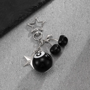Detail of keychain featuring No. 8 pool ball, black cherries and silver star pendants
