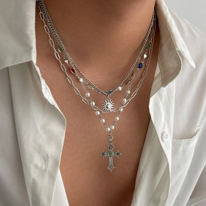 Layered silver necklace set with sun pendant, cross charm, pearls and colorful stones