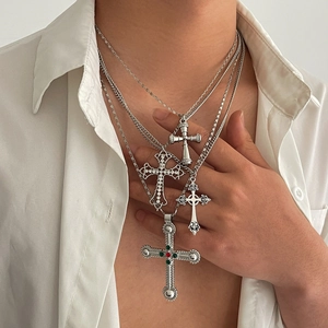 Détail de colliers superposés en alliage d'argent avec croix, strass et pierres fines