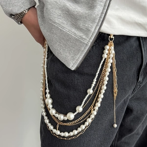 Chaîne de pantalon hip-hop multicouche avec perles blanches et franges dorées sur un jean noir