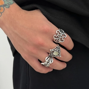 Detailed close-up of retro silver rings with heart motifs and hollow-out rock style patterns