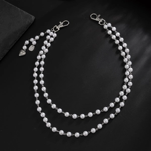 Détail de la chaîne de taille double couche en perles avec pendentif croix et fermoir
