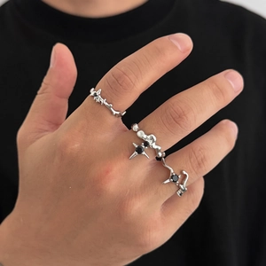 Macro detail of men's silver alloy four-point star ring set with black stones