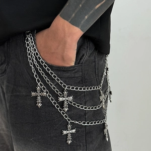 Detail of multi-layered silver gothic cross pant chains on black denim jeans
