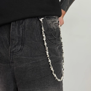 Detail of hip hop style pants chain with white pearls and silver beads on black jeans