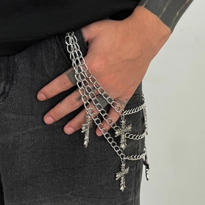 Close-up of triple-layered silver pants chain with gothic cross charms on jeans