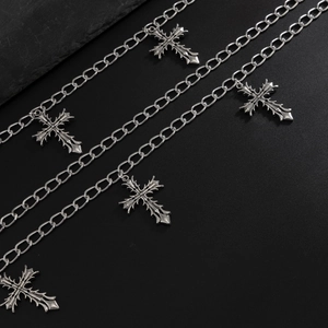 Macro detail of gothic cross pendants on a rugged silver metal punk wallet chain