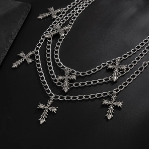 Detail of triple-layered silver metal pant chains with gothic cross pendants for women