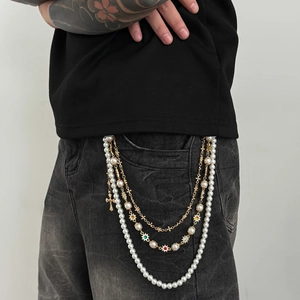 Detail of multi-layer trousers chain with pearls and colorful gemstone star charms