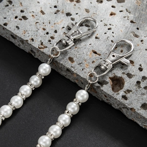 Gros plan de chaînes de pantalon en perles avec espaceurs strass et fermoirs argentés
