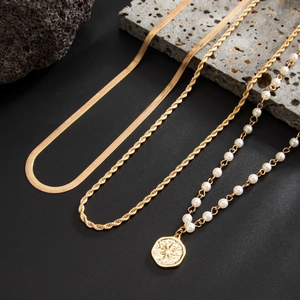 Detailed layered set of gold Cuban rope chain, snake chain and pearl coin pendant necklace