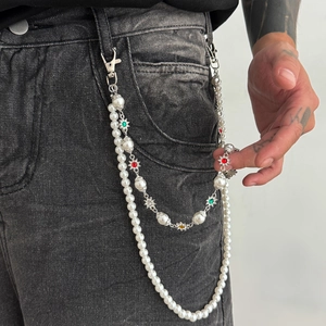 Détail d'une chaîne de jean à double rang de perles avec breloques fleurs colorées