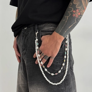 Détail d'une chaîne de pantalon punk à double rangée avec perles et pendentifs étoilés