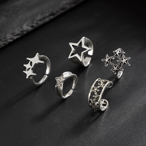 Dettaglio di un set di cinque anelli a stella in argento vintage con strass e stile punk