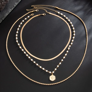 Three-layer gold necklace set featuring snake chain, pearl strand, and coin pendant