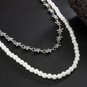 Detail of layered waist chain with white pearls and silver hollow star-shaped metal links