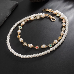 Détail du collier de perles avec breloques d'étoiles dorées et gemmes sur pierre noire