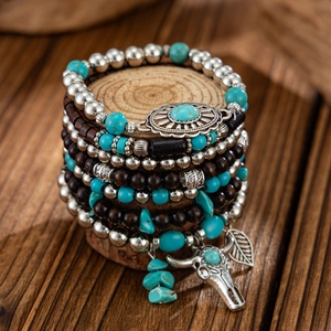 Detailed view of bohemian beaded bracelet stack with silver bull head and leaf charms