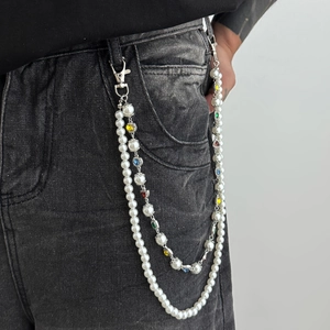 Close-up of double-layer pant chain with white pearls and colorful rhinestones on black jeans