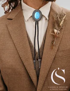 Detail of vintage silver bolo tie with turquoise stone on leather cord and suit