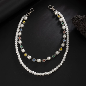 Double-layered pearl chain with colorful gems and silver lobster clasps on black rock
