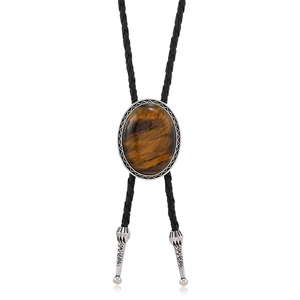 Detail of tiger eye stone bolo tie with engraved silver metal casing and black braided leather
