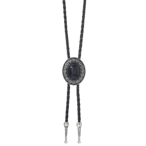 Detail of vintage bolo tie showing engraved metal frame and black stone decoration