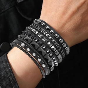 Close-up of men punk multi-layer black leather bracelets with studs and metal chains