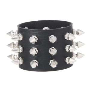 Detailed view of punk leather bracelet with triple-row silver cone spikes and snap buttons